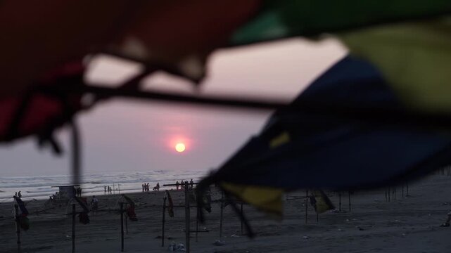 Stunning Sunset at Parangtritis Beach, Yogyakarta - Serene Ocean View with Silhouetted People and Rustic Beach Decor