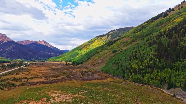 Aerial view of Red Mountain peaks overlooking golden autumn aspen forests near historic Ironton along Million Dollar Highway Colorado