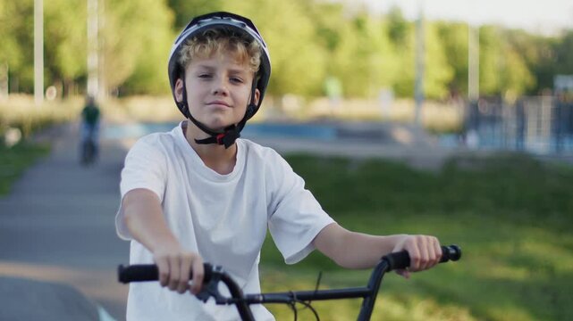 Portrait of 10 Year Old Boy in Helmet Riding BMX Bicycle Outdoors
