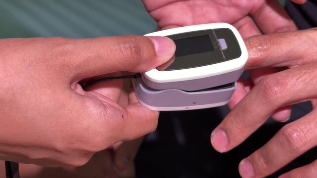 Close up of pulse oximeter on patient finger measuring blood oxygen level