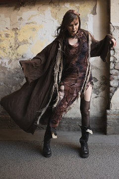 Swirling brown cloak in motion, woman with outstretched arm, sorceress style post-apocalyptic look