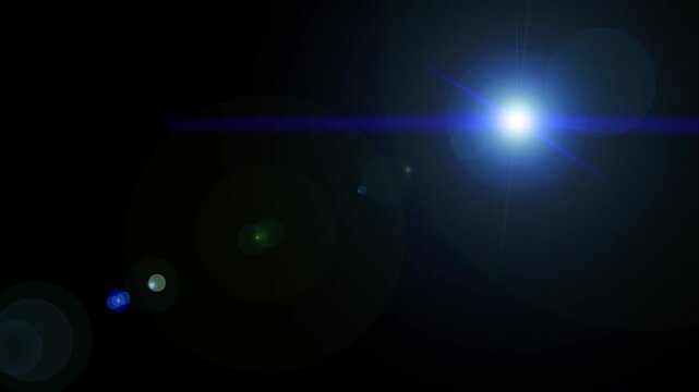 Bright blue optical lens flare shining with glowing light rays on a solid black background.