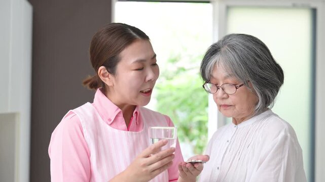 訪問介護で高齢者の服薬を支援する介護福祉士や看護師の女性ホームヘルパー、在宅介護、薬、服薬確認、水を渡すイメージの動画