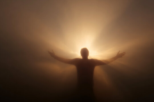 Human silhouette with radiant golden auric light for spiritual background and meditation poster design