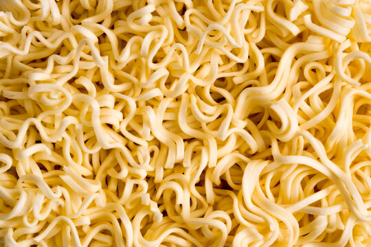 Dry instant noodles forming abstract pattern background