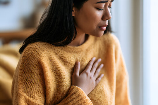 Young Woman Holding Chest with Eyes Closed Breathing Deeply