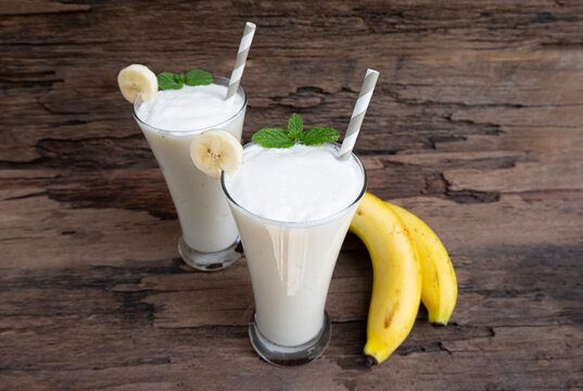 Banana fresh cocktail vanilla smoothies  fruit juice beverage healthy the taste yummy in glass drink episode good morning on wooden background from the top view.