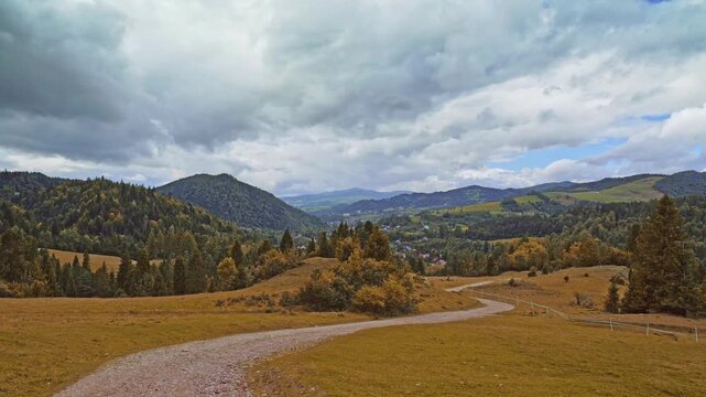 A picturesque panorama of the Pieniny mountain range in the Malopolska region, Poland. scenic view of golden rolling hills and mixed forest under a cloudy sky during late summer or early fall
