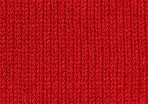 Red knitted wool texture background with vertical ribbed pattern close up