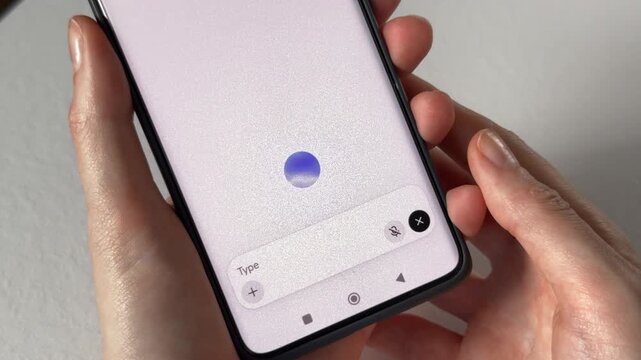 User interacting with conversational artificial intelligence voice model via smart mobile application interface. Modern cell phone display showing a digital glowing circle for smart audio speech