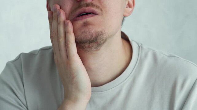 A person holding their cheek due to a toothache.
Tooth decay and cheek swelling.
Periodontal disease.