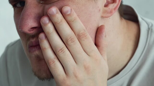 A person holding their cheek due to a toothache.
Tooth decay and cheek swelling.
Periodontal disease.
