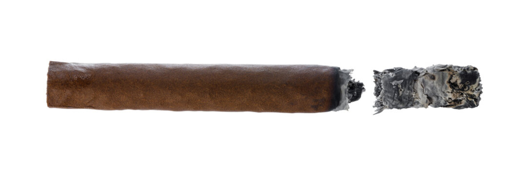 Cigar placed on a flat surface with a burnt end showing the ash and tobacco