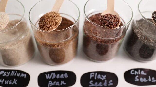 Fibermaxxing: diverse fiber ingredients in glass cups with psyllium husk, chia, flax, and bran