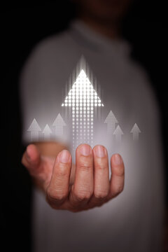 Hand holding dotted upward arrows. Business growth, corporate success, growing financial trend increase, performance enhancement, and strategic progress to grow and rise up. Vertical stock photo.