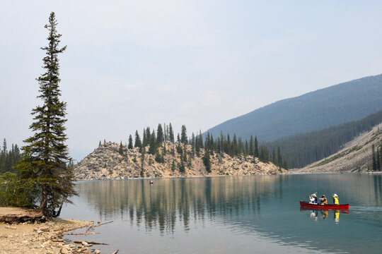 Tourists using the canoe at lake Moraine on Banff national park in Canada