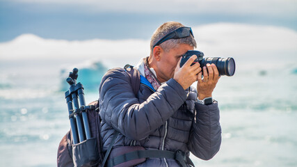Professional photographer exploring icy landscape at Jokulsarlon glacial lake in summer © jovannig