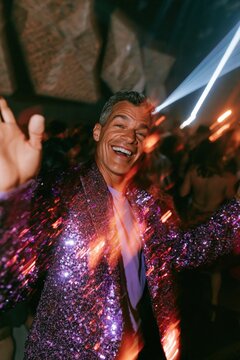Cheerful man dancing in sparkling sequin jacket at lively club for event poster and celebration background