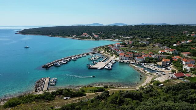 Aerial drone panorama of the eastern part of Silba Island, Croatia, surrounded by the crystal-clear Adriatic Sea. The picturesque coastal village, turquoise shoreline and Mediterranean vegetation