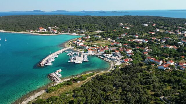 Aerial drone panorama of the eastern part of Silba Island, Croatia, surrounded by the crystal-clear Adriatic Sea. The picturesque coastal village, turquoise shoreline and Mediterranean vegetation