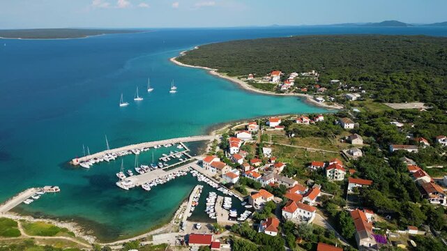 Aerial drone panorama of the eastern part of Silba Island, Croatia, surrounded by the crystal-clear Adriatic Sea. The picturesque coastal village, turquoise shoreline and Mediterranean vegetation