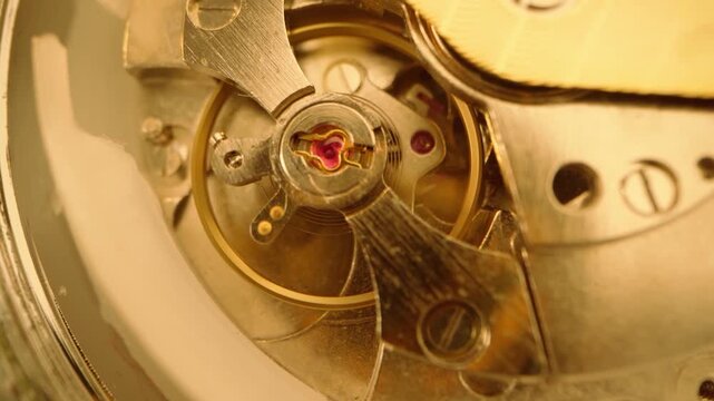 Macro closeup view of the intricate mechanical movement inside a luxury wristwatch, showcasing the balance wheel, hairspring, and jeweled bearings