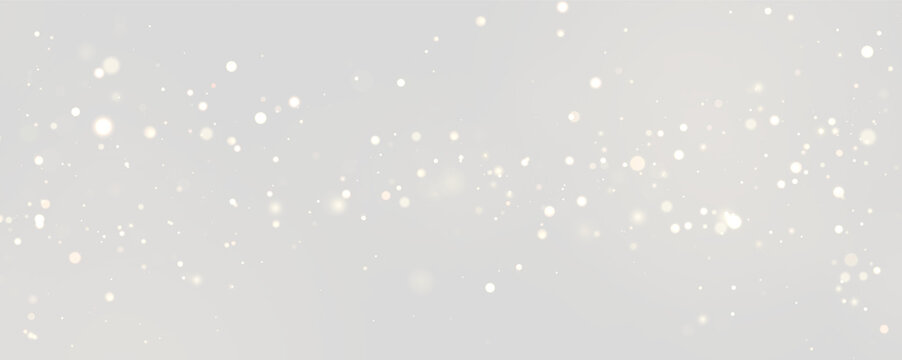 Golden bokeh light particles float gracefully against a dark background. They exhibit soft, varied sizes and gentle glowing effects scattered across the frame.