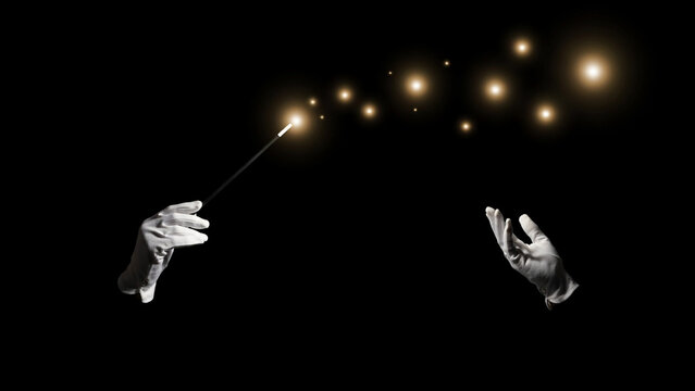 Hands holding a magic wand creating glowing sparkles in dark background with copy space