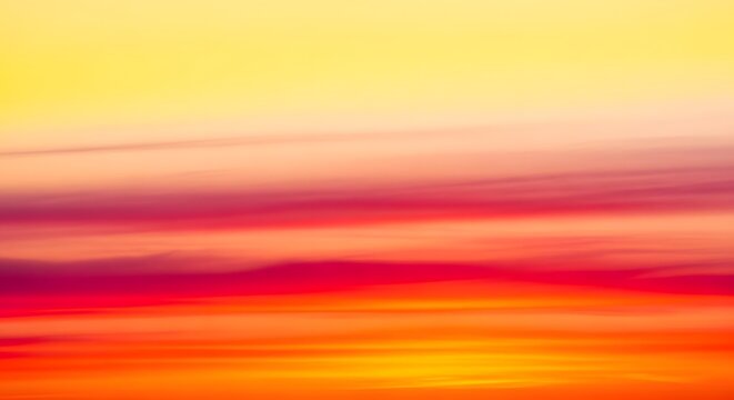 Abstract background with smooth flowing streaks of vibrant red orange yellow and bright light colors creating dynamic motion and energy effect suitable for modern digital art and creative design.