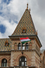 Steep tiled tower and Hungarian flag above the Great Market Hall at Fovam Square in central Budapest, Hungary © Guillaume Angleraud