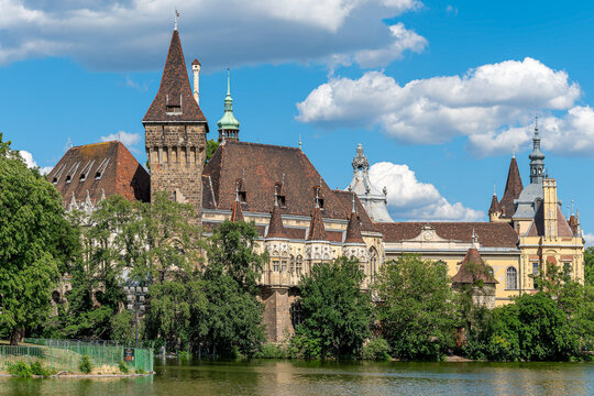 Vajdahunyad Castle reflected in a still lake with mixed gothic, romanesque and baroque towers in City Park Budapest, Hungary