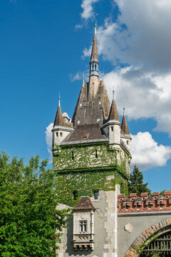 Ivy covered stone gate tower with pointed spires at the entrance to Vajdahunyad Castle in City Park Budapest, Hungary