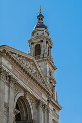 Bell tower and dome of St Stephen's Basilica seen above a pediment inscribed with a Latin motto in Budapest, Hungary © Guillaume Angleraud