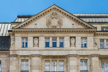 Pediment with a carved coat of arms and urns on the stone facade of the Ministry of Finance in Budapest, Hungary © Guillaume Angleraud