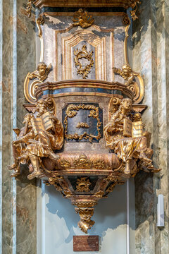 Gilded pulpit with statues of evangelists holding open books in the Servite Church of Pest in Budapest, Hungary