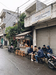 Obraz premium A group of friends enjoying coffee at an outdoor cafe on a rainy day