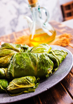 cabbage leaves with minced meat, rice, onion, spices on wooden table. Traditional Eastern European food preparation concept.