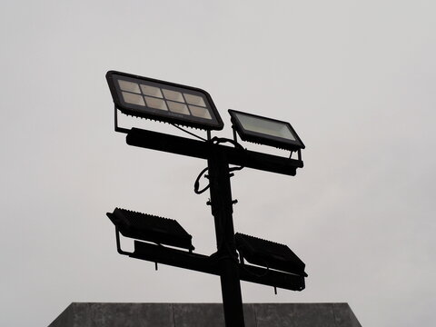 LED Floodlight Pole : Features four high-output floodlights mounted on steel structure, designed for wide-area outdoor illumination. High-power LED floodlights for illuminating large spaces. 
