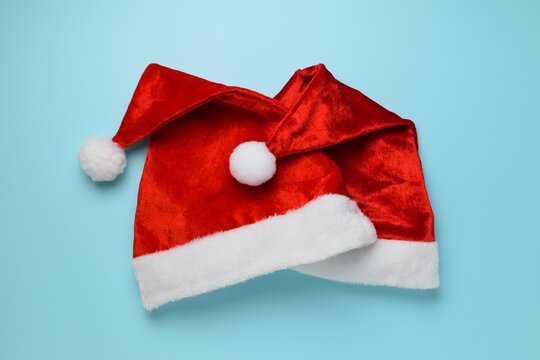 Santa Claus hats on a blue background. Traditional red Santa hats with white fur