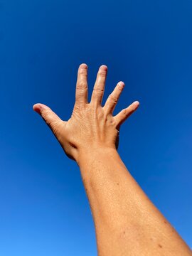 Mano aperta nel cielo blu