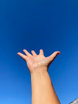 Mano aperta nel cielo blu
