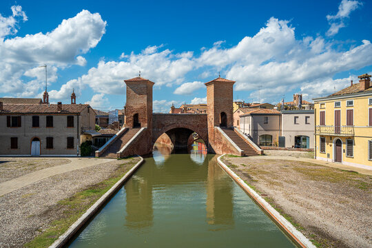 The monumental Trepponti bridge reflected in the central canal of Comacchio, Italy