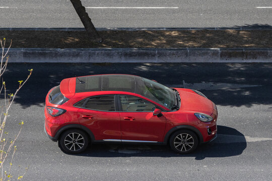 Red ford puma subcompact crossover suv driving on urban road