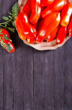 Fresh red tomatoes on plate and on wooden table