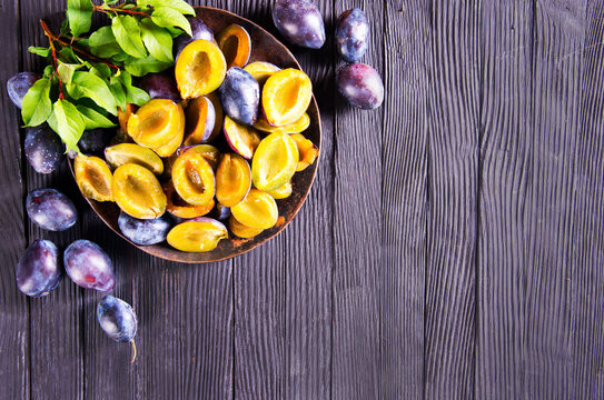 Plums on wooden background