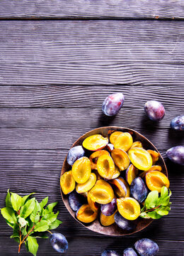 Plums on wooden background