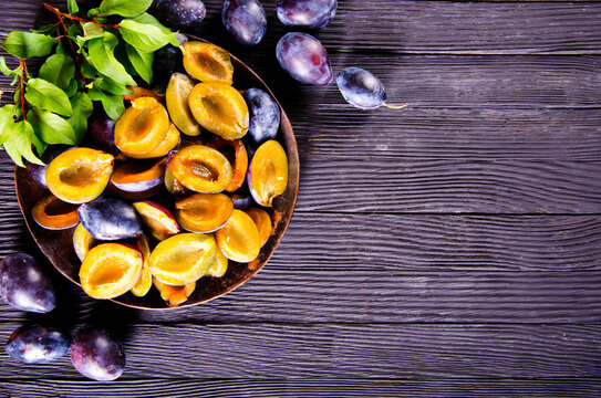 Plums on wooden background