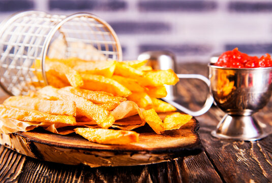 Crisp golden brown curly fried potato with rich red tomato dipping sauce close-up for snack or appetizer