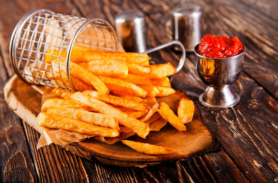 Crisp golden brown curly fried potato with rich red tomato dipping sauce close-up for snack or appetizer