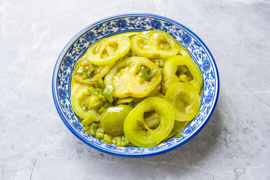 A plate of vegetables on the dining table&mdash;stir-fried green tomatoes.